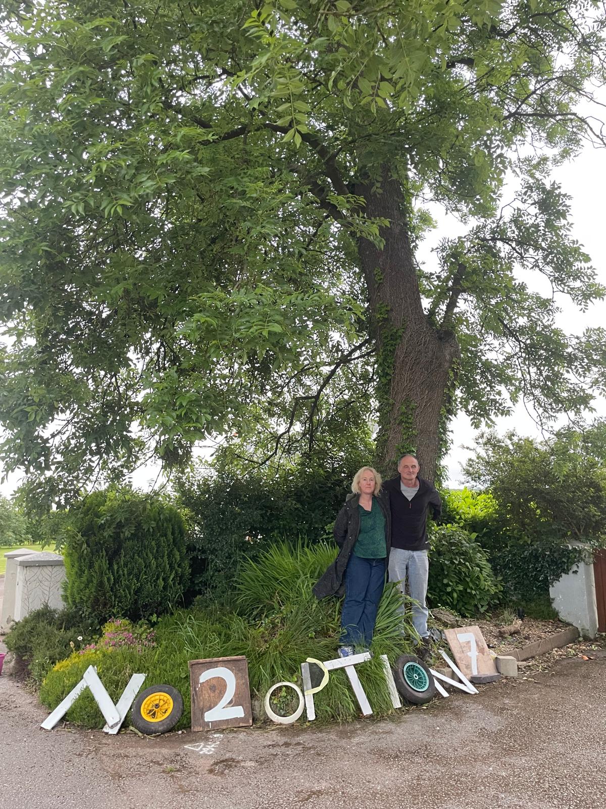 Residents with No 2 Option 7 sign under a mature tree